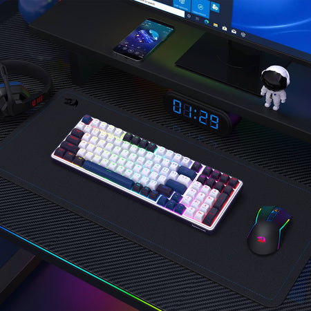 Gaming desk setup with keyboard, mouse, and monitor on a dark surface