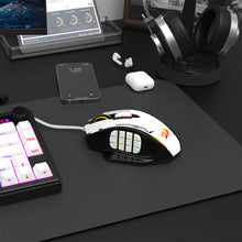 Gaming mouse on a desk with keyboard, phone, and headphones in the background