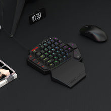 Black ergonomic keyboard with RGB backlighting on a dark surface, next to a mouse and digital clock.